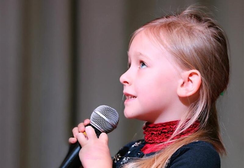 Young girl speaking into a microphone